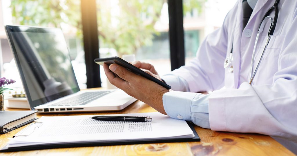 doctor holding a phone telehealth for mental health treatment