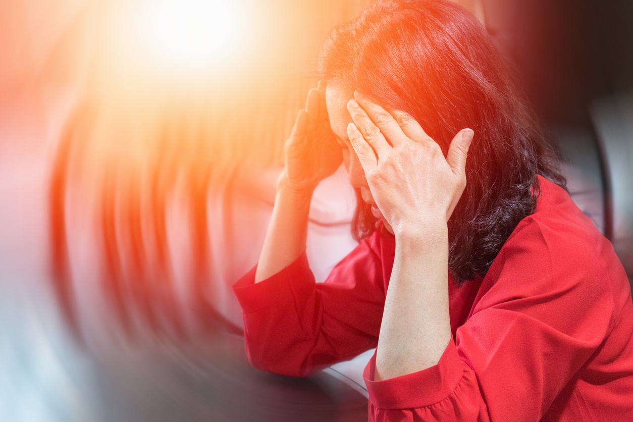 Woman experiencing an anxiety attack. Overwhelmed, hands on her head