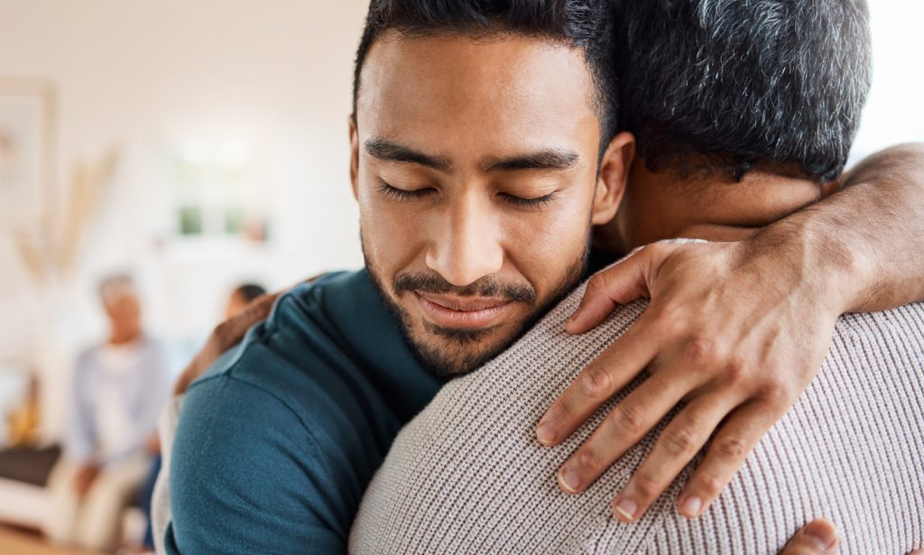 Shot of a father and son hugging at home